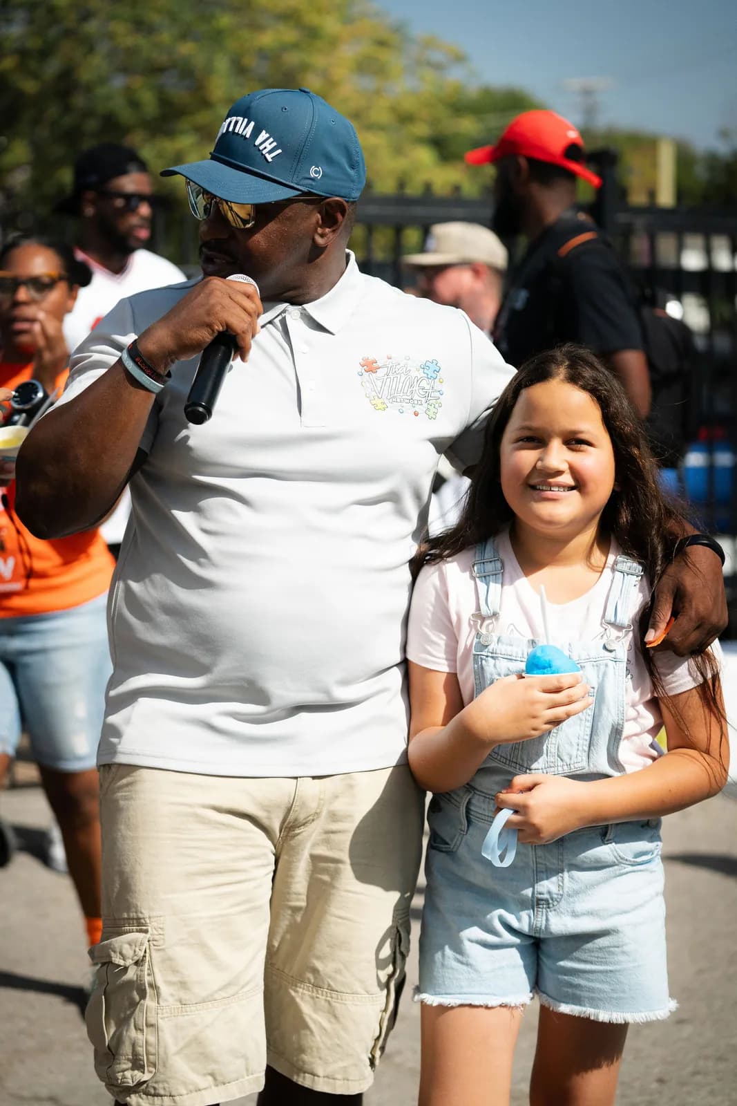 A child smiling with Iced Out water ice at a Dear Fathers community event