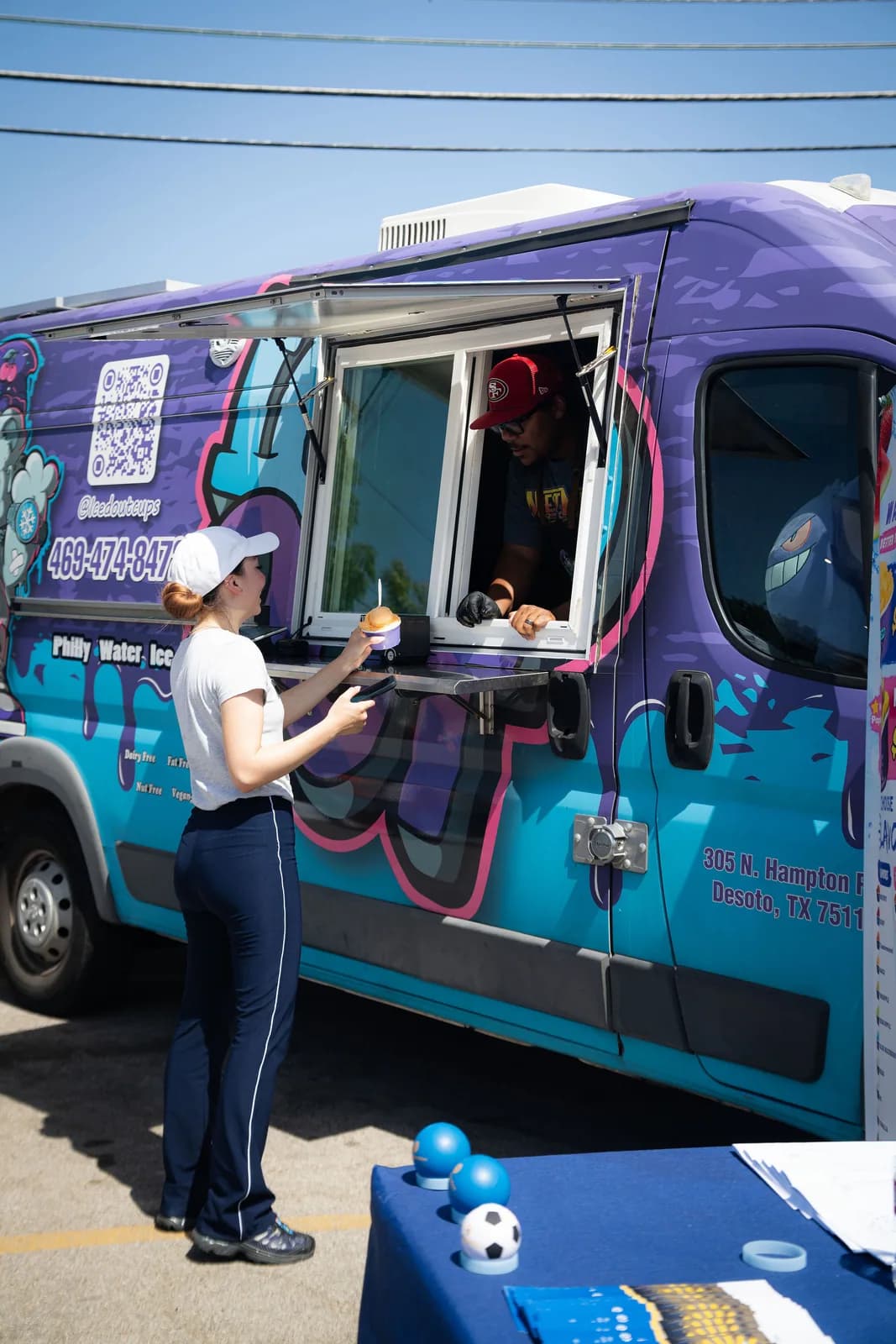 A guest receiving water ice from the Iced Out truck at a Dear Fathers event