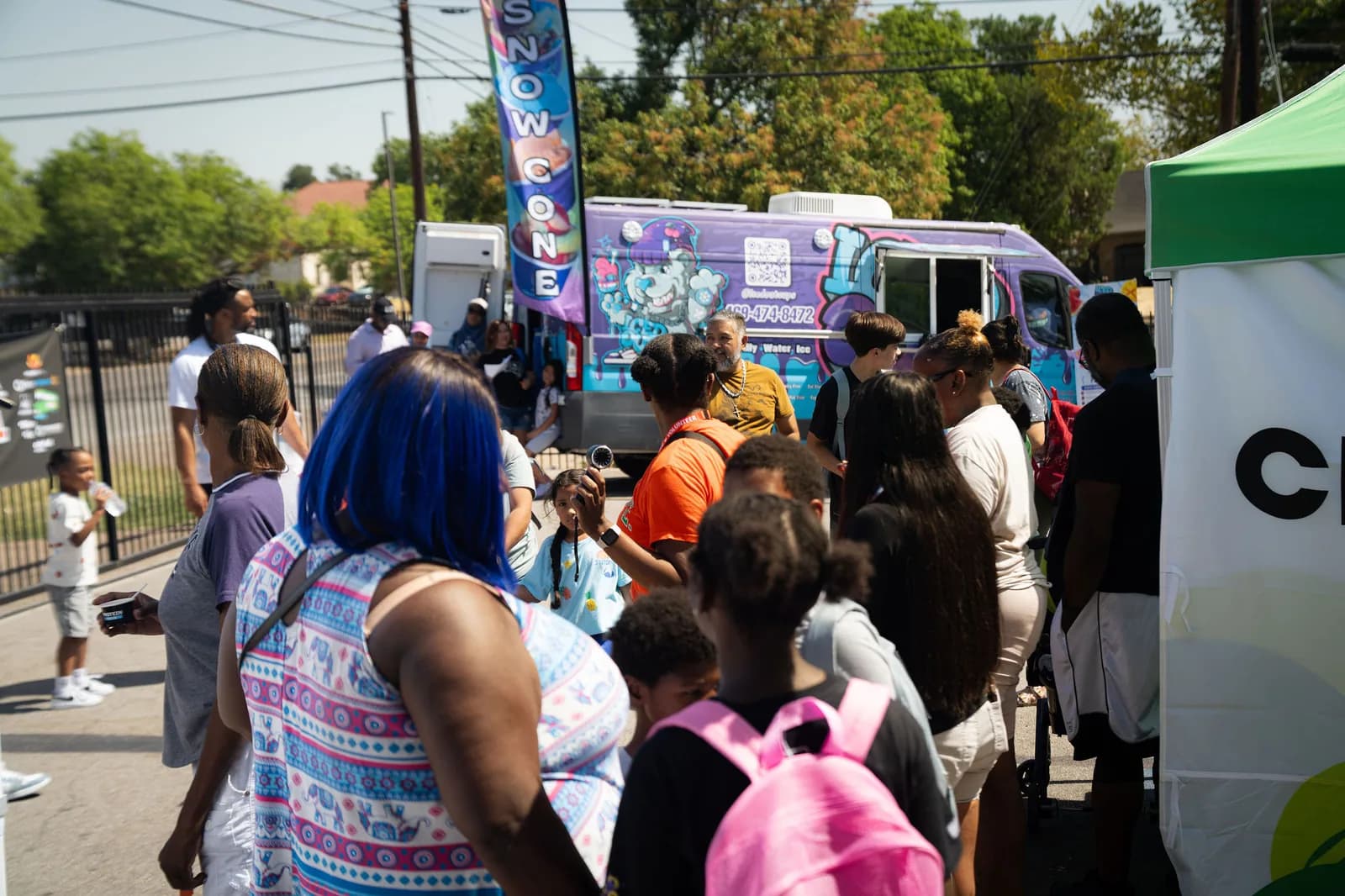 Families gathered near the Iced Out truck at a Dear Fathers community event