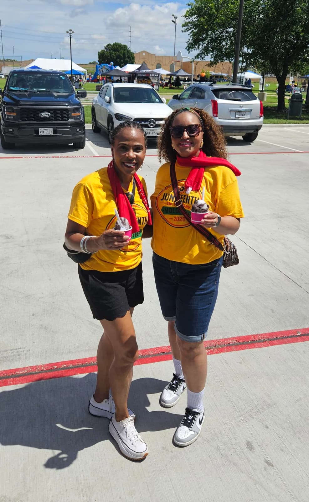 Two volunteers enjoying Iced Out water ice at a Parrish Charitable Foundation event