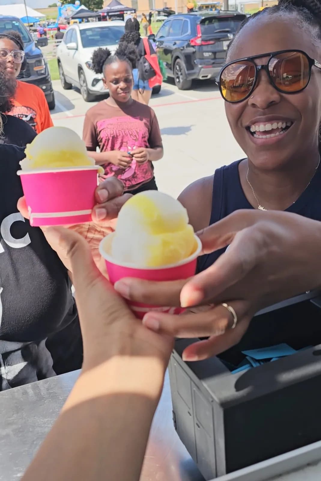 Guests holding several colorful cups of Iced Out water ice at a Parrish Charitable Foundation event