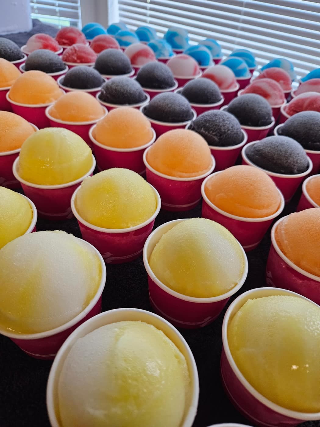 Top-down view of rows of colorful pre-scooped cups on the truck counter