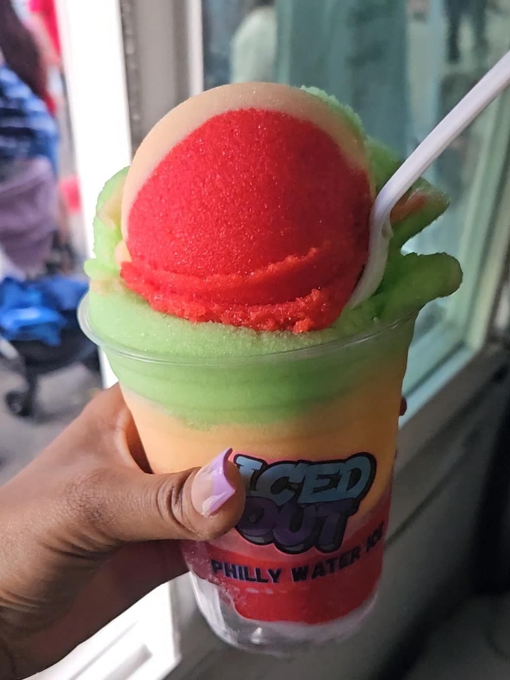 A layered Iced Out cup held up at an evening event