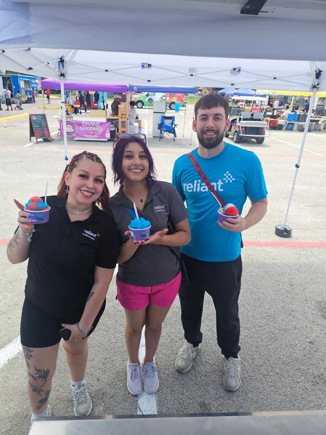 Iced Out team serving guests holding cups at an outdoor event